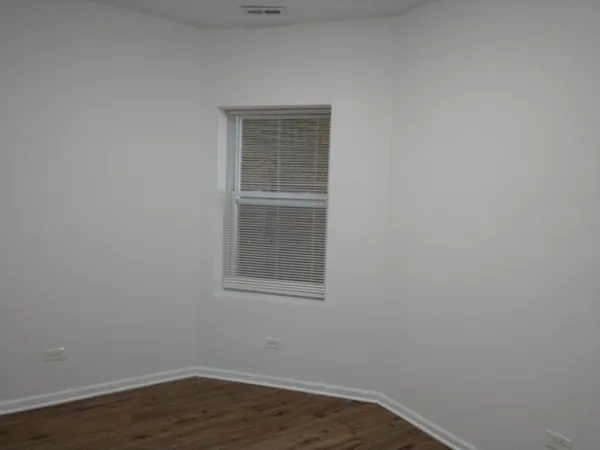 a view of a small space with wooden floor and a window