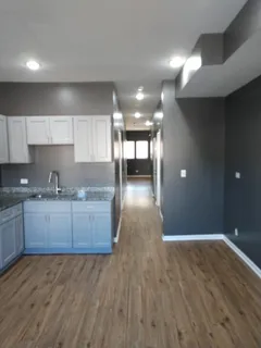 a kitchen with granite countertop a stove and a wooden floors