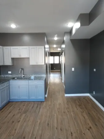 a kitchen with granite countertop a stove and a wooden floors