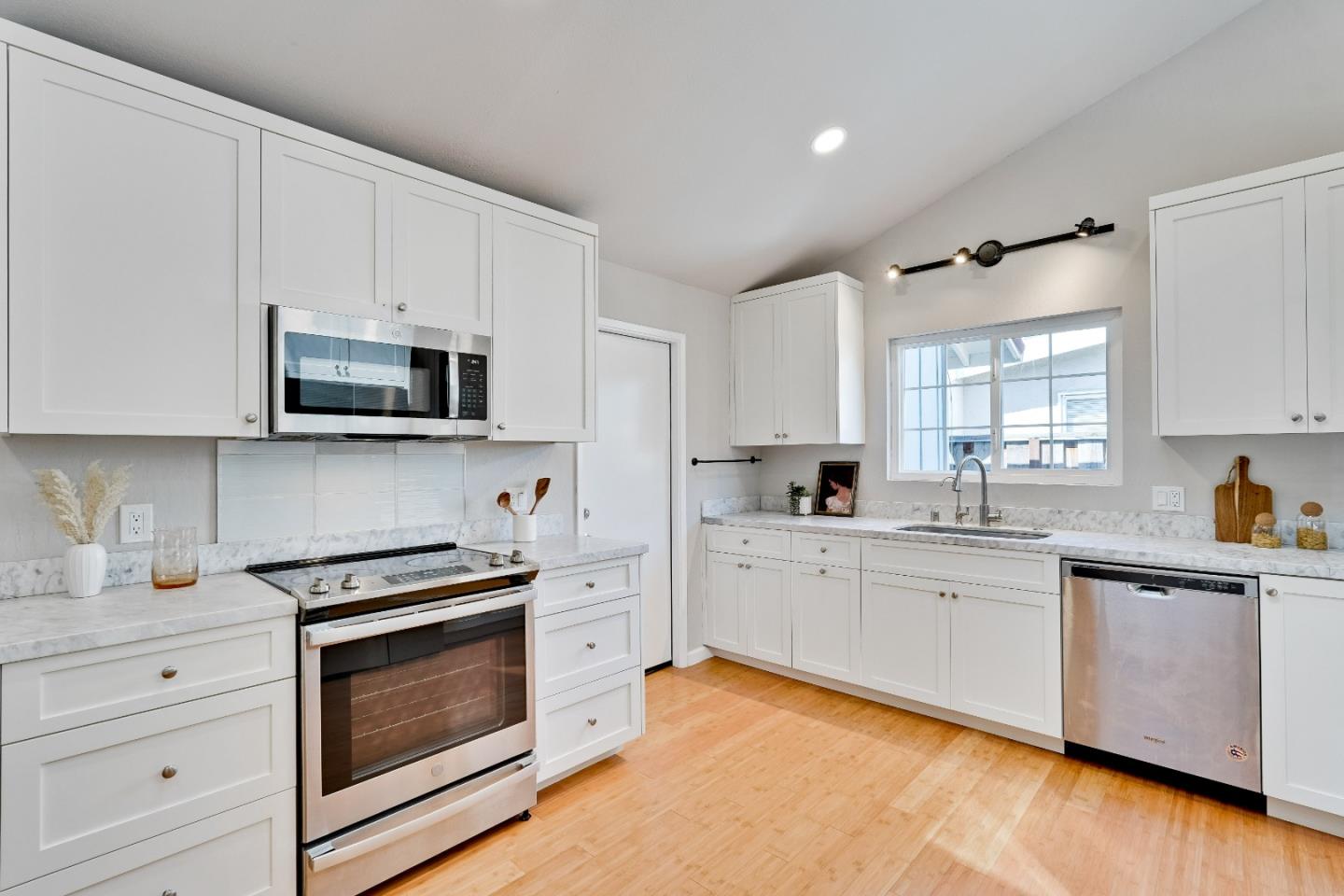 1755 Ravizza Avenue Santa Clara, CA 95051 - Photo 15 of 36 a kitchen with stainless steel appliances white cabinets a sink and a stove
