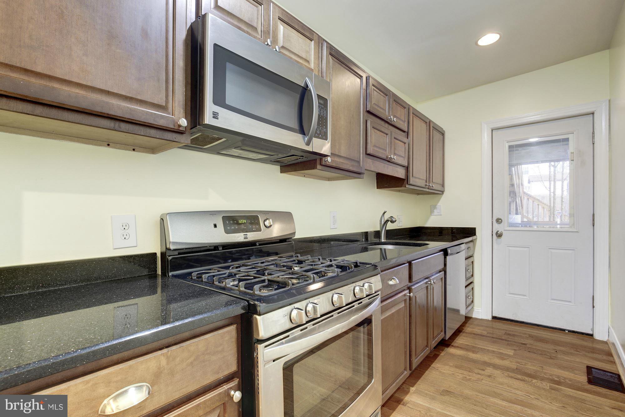 1241 Jackson Street Northeast Washington, DC 20017 - Photo 11 of 30 a kitchen with stainless steel appliances granite countertop a stove and a microwave