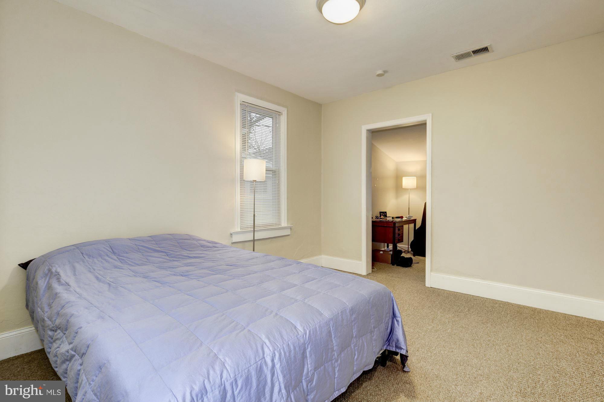 1241 Jackson Street Northeast Washington, DC 20017 - Photo 20 of 30 a bed sitting in a spacious bedroom next to a window and a bathroom