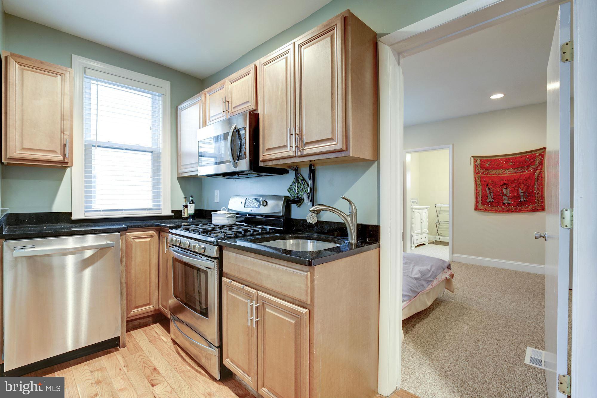 1241 Jackson Street Northeast Washington, DC 20017 - Photo 6 of 30 a kitchen with stainless steel appliances granite countertop a stove a sink and a microwave