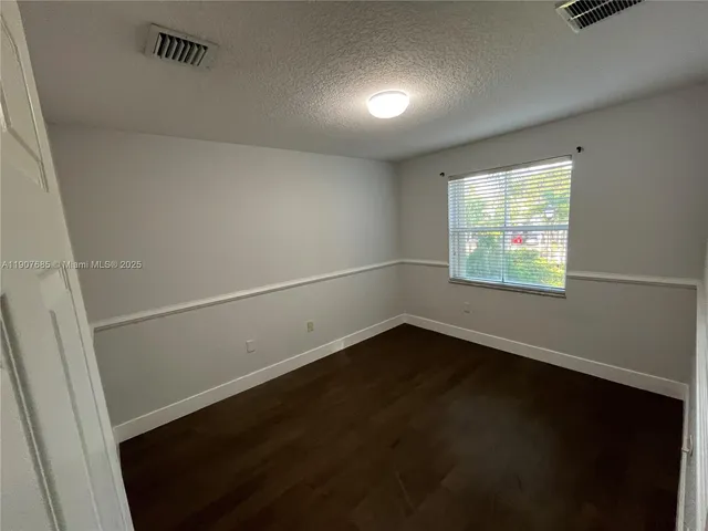 an empty room with wooden floor and white walls