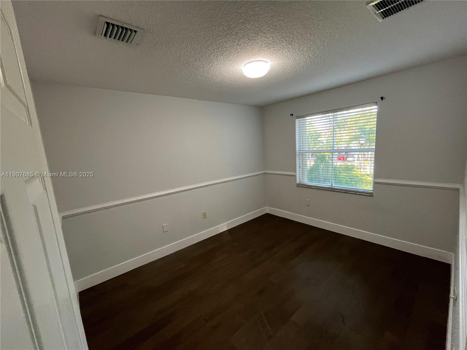 4790 Southwest 165th Avenue Miramar, FL 33027 - Photo 23 of 31 an empty room with wooden floor and windows