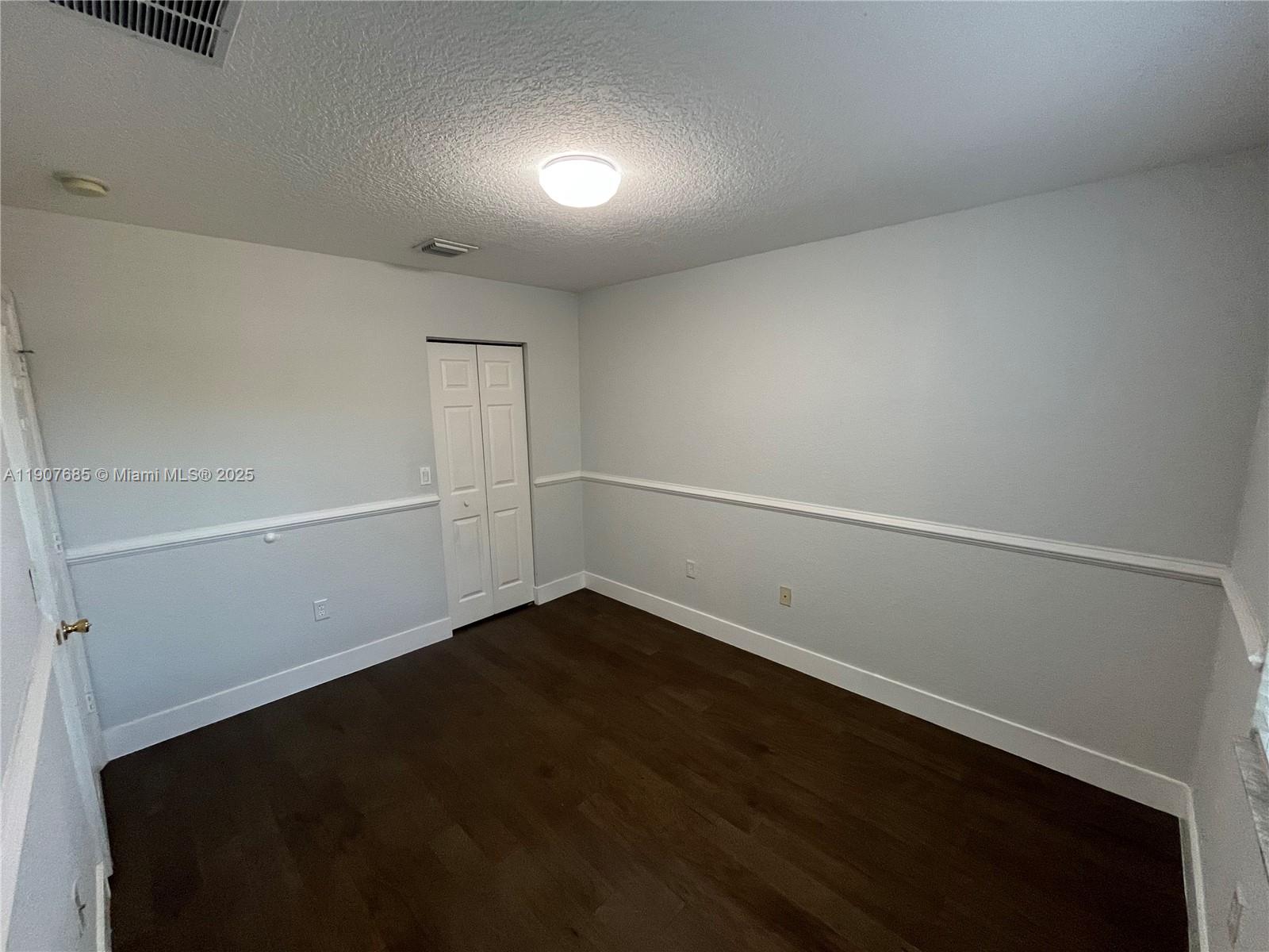 4790 Southwest 165th Avenue Miramar, FL 33027 - Photo 24 of 31 an empty room with wooden floor and white walls