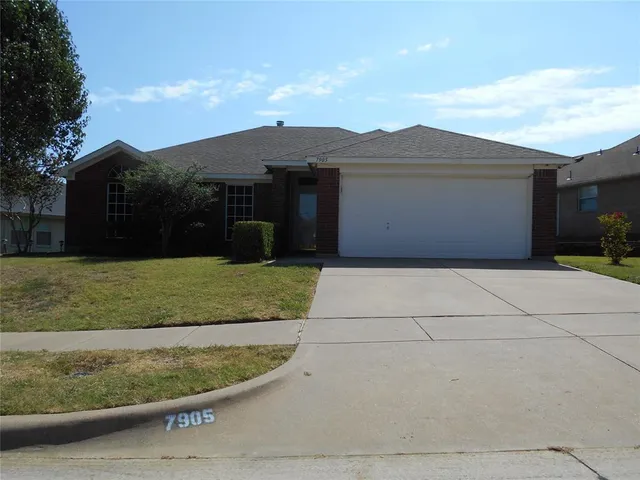 a view of a house with a yard and large tree
