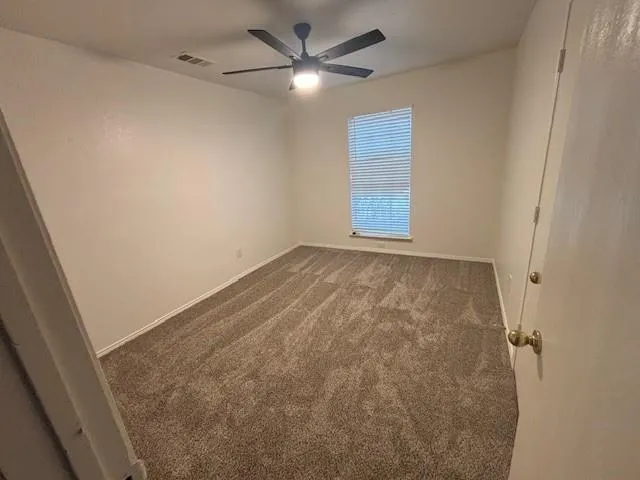 an empty room with windows and fan