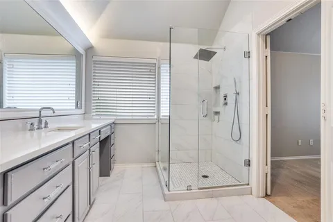 a bathroom with a shower sink and mirror