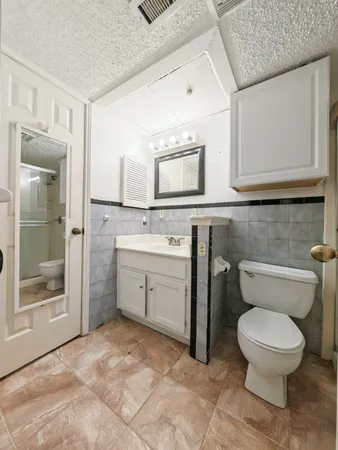 a bathroom with a toilet sink and mirror