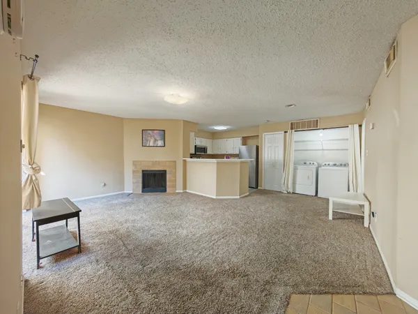 a view of a livingroom with an empty space and a fireplace