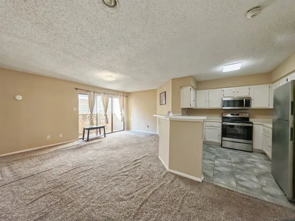 a view of a kitchen with wooden floor and electronic appliances