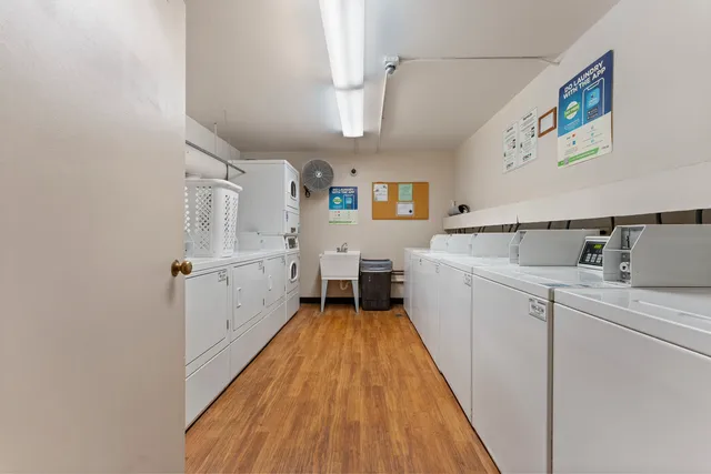 a view of a kitchen with fridge and wooden floor