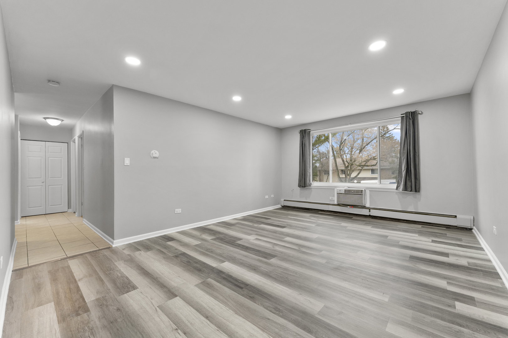1500 Robin Circle, Unit 203 Hoffman Estates, IL 60169 - Photo 2 of 13 a view of an empty room with a window and wooden floor