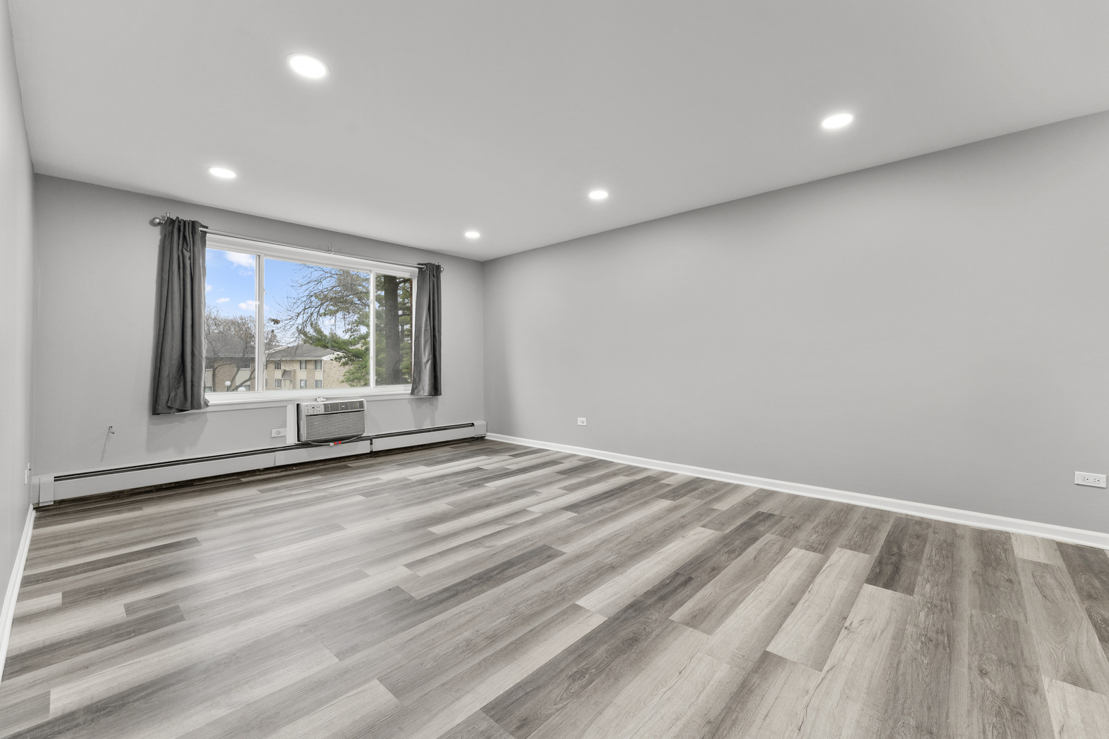 1500 Robin Circle, Unit 203 Hoffman Estates, IL 60169 - Photo 3 of 13 an empty room with wooden floor and windows