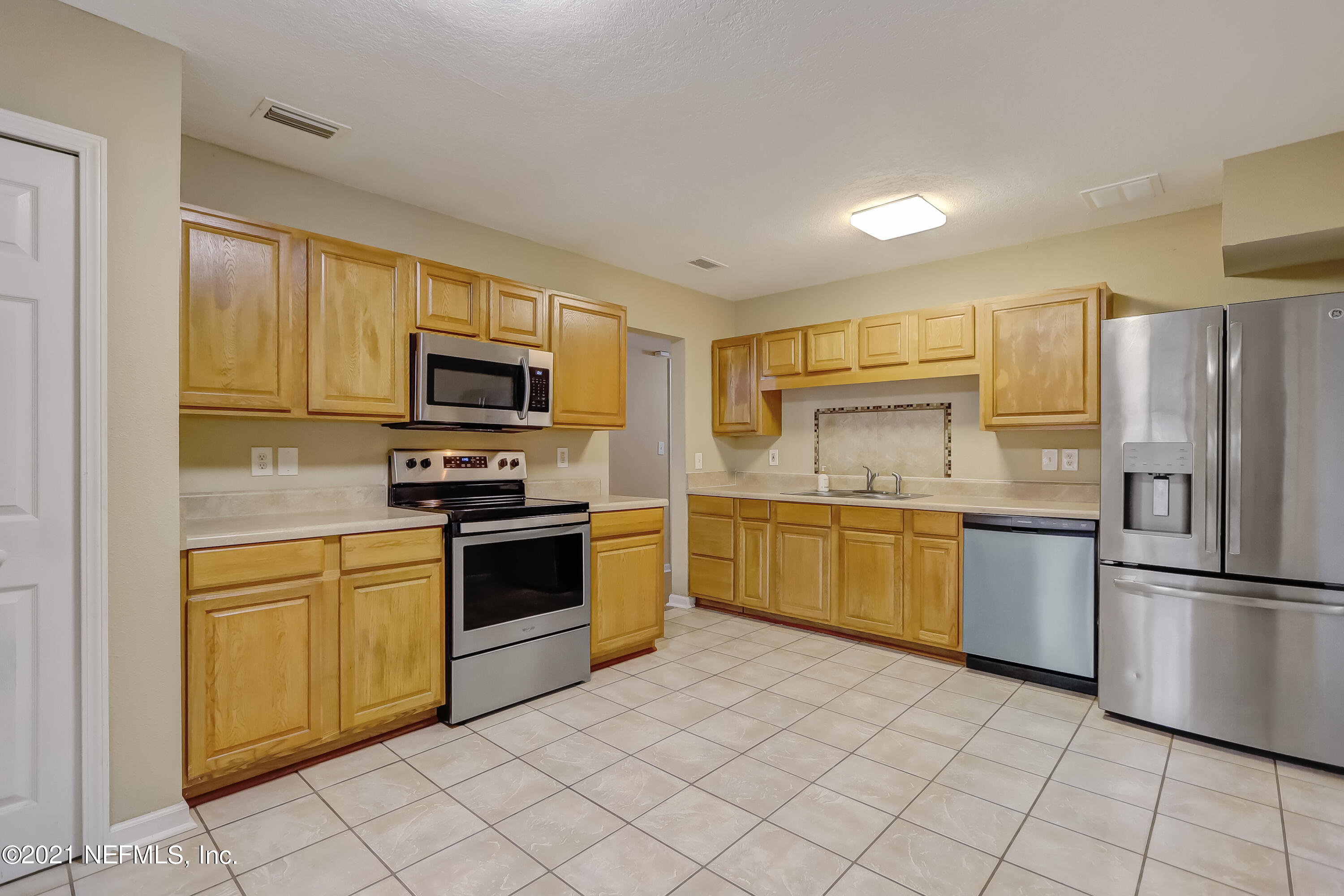 5207 Sunderland Road Jacksonville, FL 32210 - Photo 9 of 23 a kitchen with a sink stainless steel appliances and cabinets