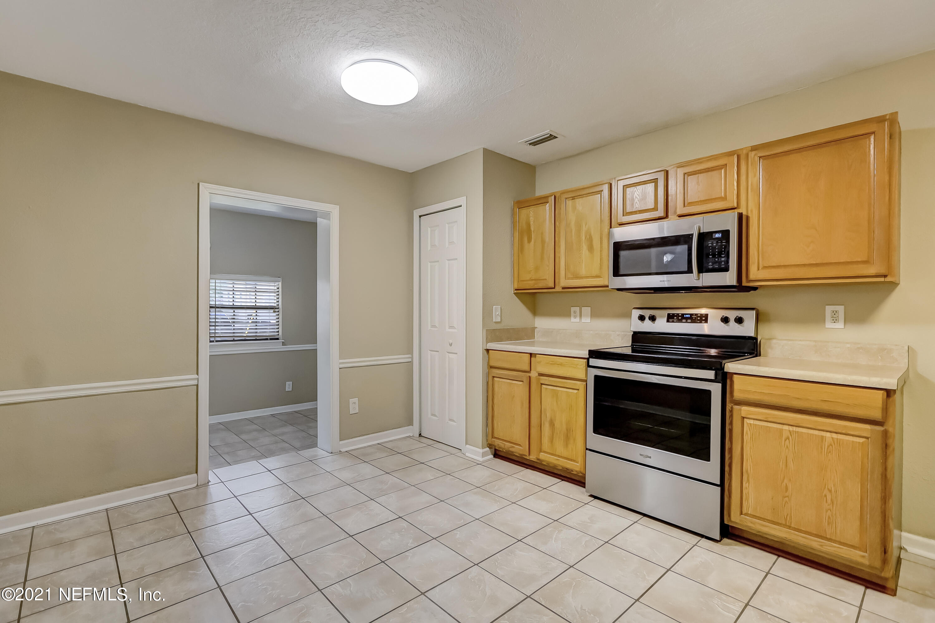 5207 Sunderland Road Jacksonville, FL 32210 - Photo 10 of 23 a kitchen with granite countertop a stove and a refrigerator