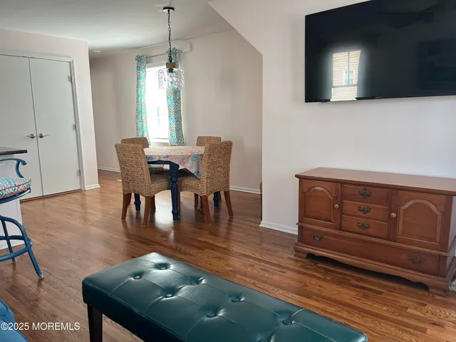 a dining room with furniture a chandelier and wooden floor
