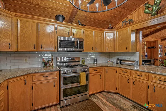 a kitchen with stainless steel appliances granite countertop a stove and cabinets