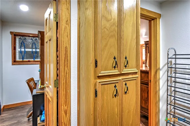 a view of a hallway with wooden shelves