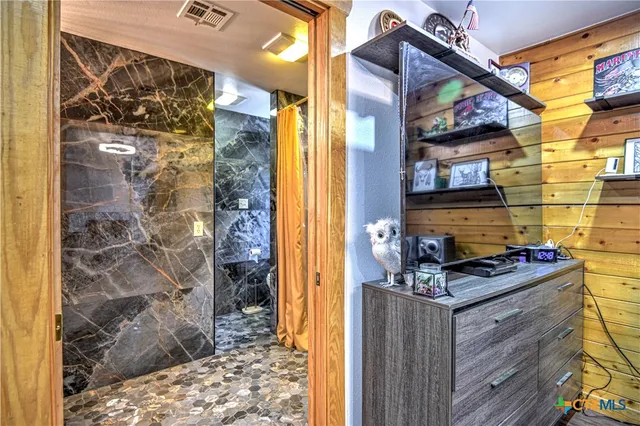 a bathroom with a granite countertop shower a sink and a shower