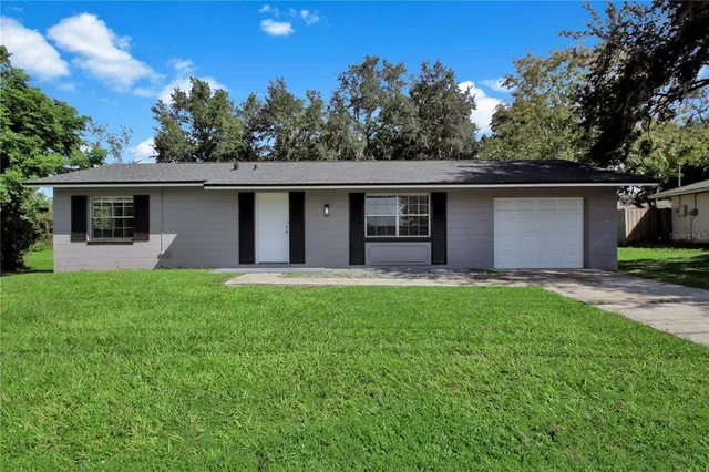 a front view of house with yard and green space