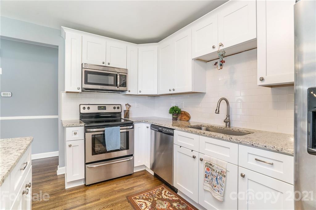 4235 Sudbury Road Charlotte, NC 28205 - Photo 6 of 29 a kitchen with granite countertop a sink cabinets stainless steel appliances and a counter space