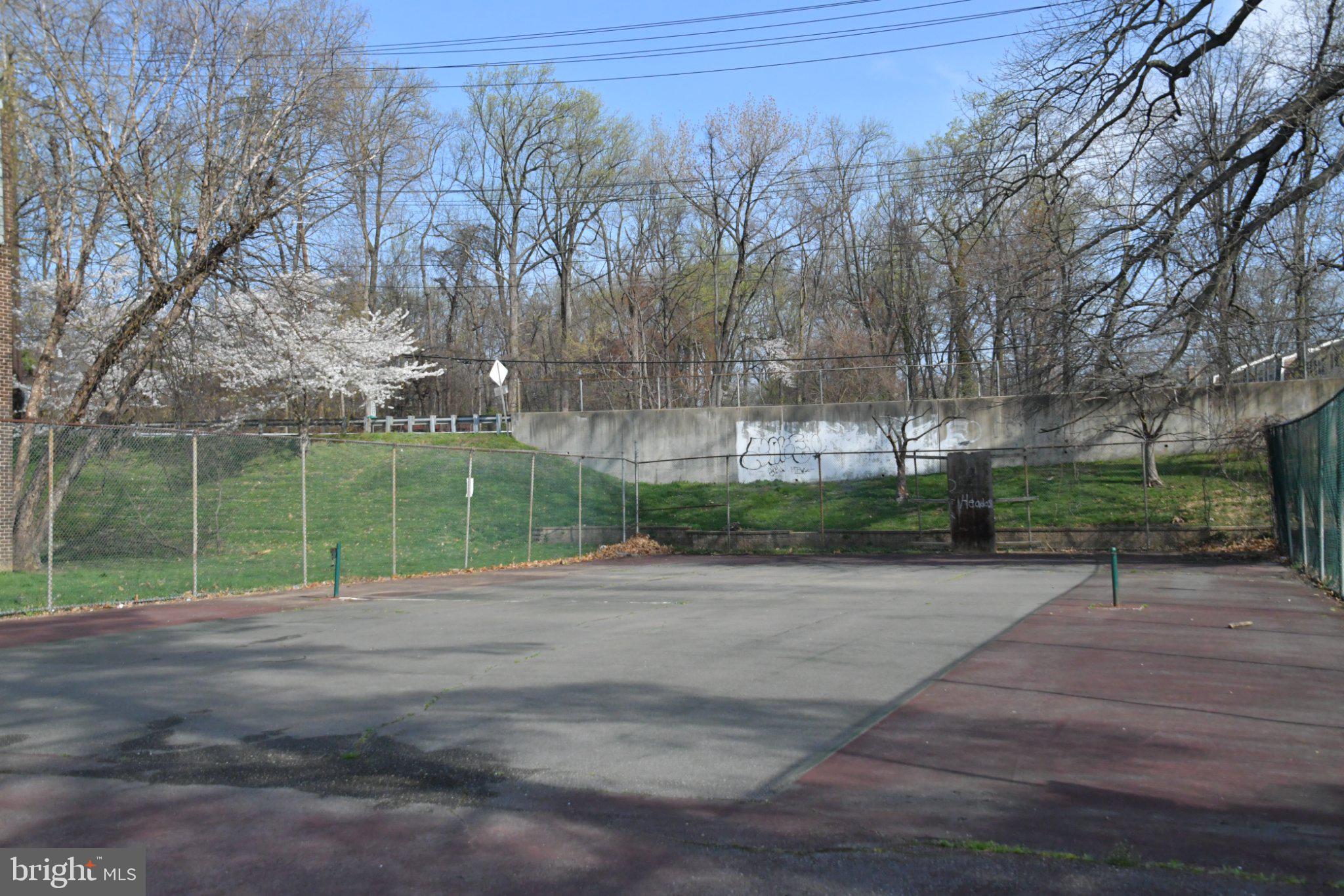 3932 Bel Pre Road, Unit 39326 Silver Spring, MD 20906 - Photo 18 of 20 Serene tennis court in nature's embrace.
