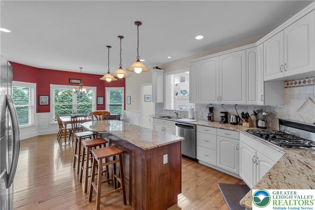 774 Lahr Road Nazareth, PA 18064 - Photo 16 of 58 a kitchen with stainless steel appliances granite countertop a stove a sink dishwasher and a dining table with wooden floor