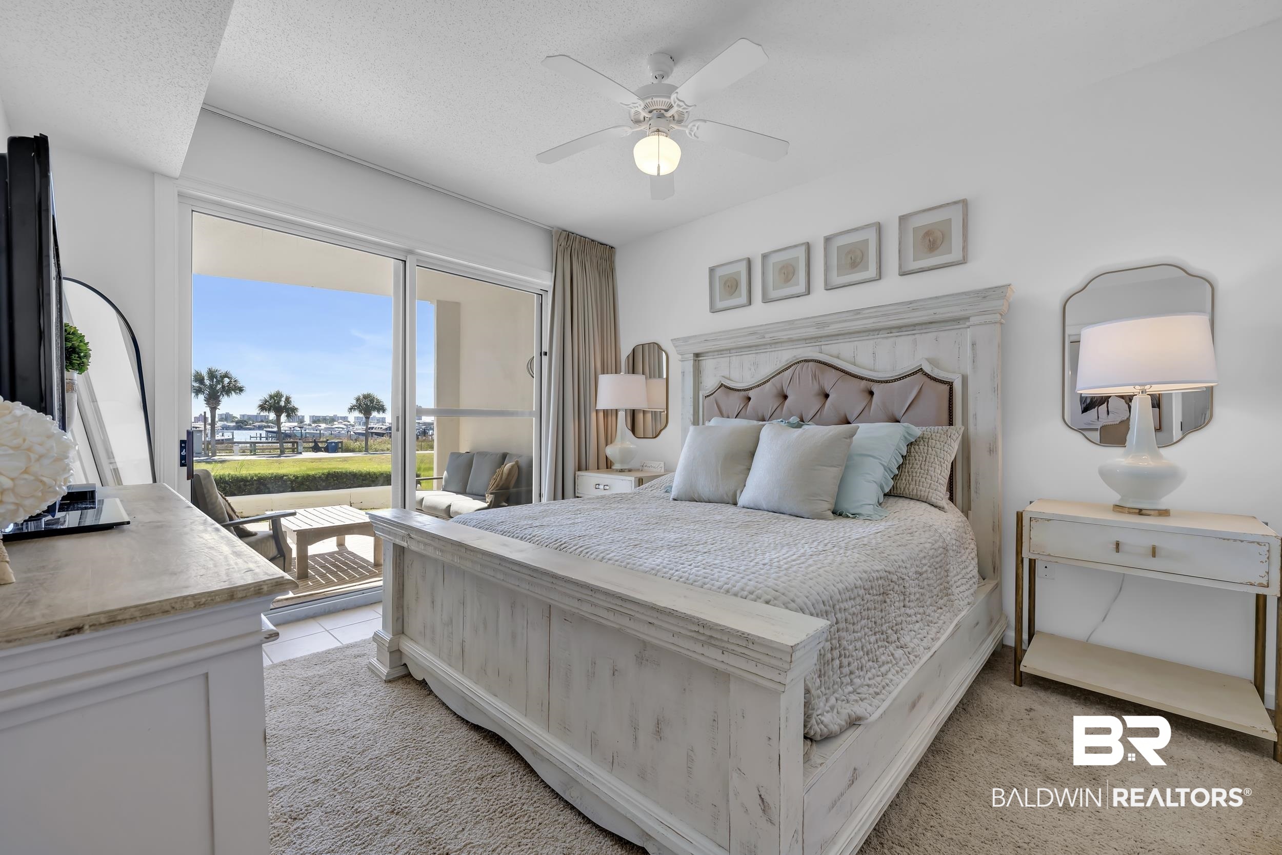 27282 Canal Road, Unit 104 Orange Beach, AL 36561 - Photo 30 of 79 Bedroom featuring access to outside, a ceiling fan, light carpet, light tile patterned flooring, and a textured ceiling