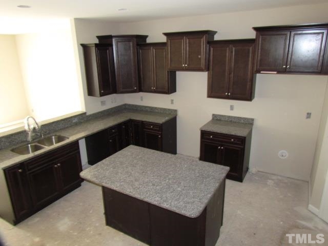 4623 Pat Reed Road Raleigh, NC 27616 - Photo 3 of 13 a kitchen with granite countertop a refrigerator and a stove top oven