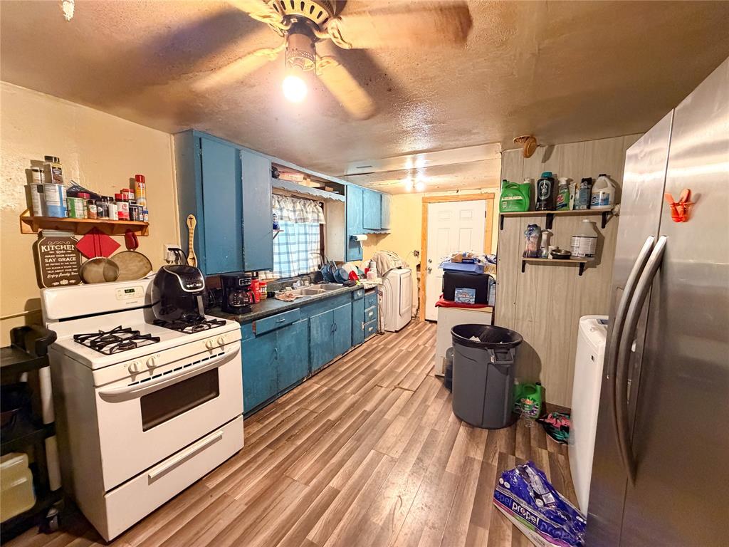 506 North Ave B Haskell, TX 79521 - Photo 5 of 13 a kitchen with stainless steel appliances kitchen island granite countertop a stove refrigerator and cabinets