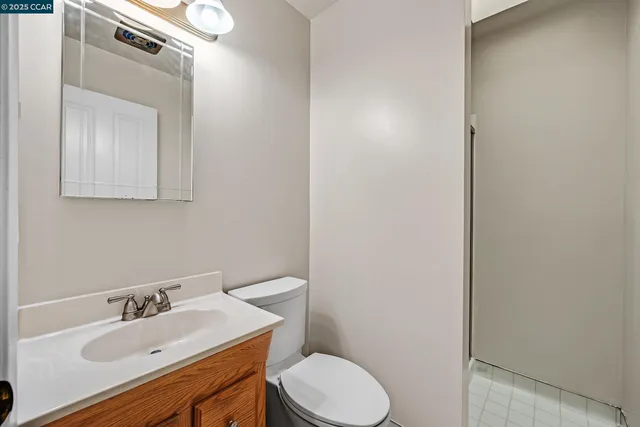 a bathroom with a sink vanity mirror and toilet