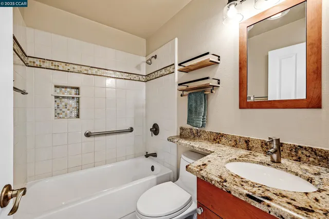 a bathroom with a granite countertop sink toilet and shower