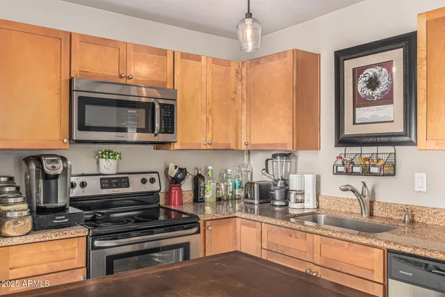 a kitchen with stainless steel appliances granite countertop a stove microwave and sink