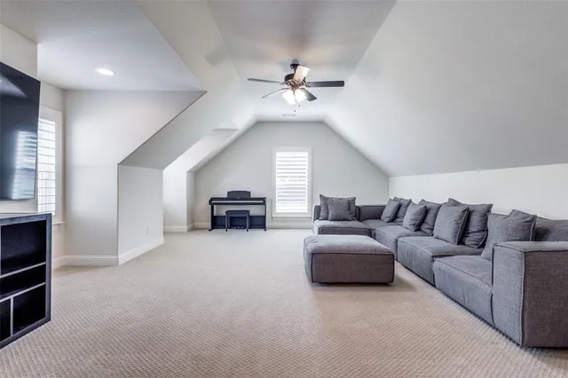 a living room with furniture and a ceiling fan