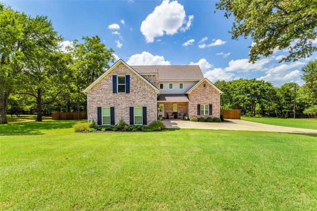 a front view of a house with yard and green space