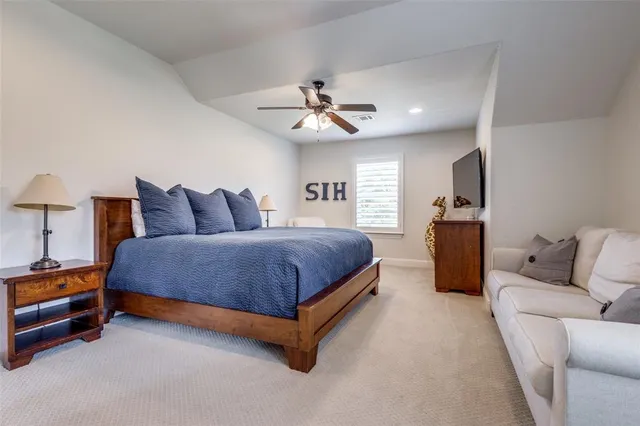 a spacious bedroom with a bed and a ceiling fan
