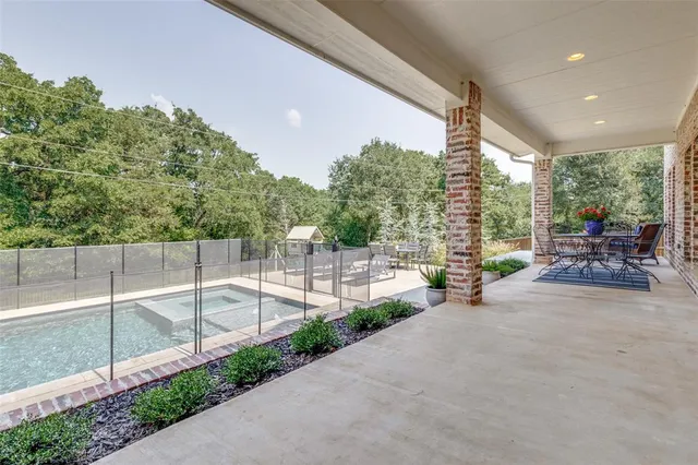 a view of a patio with a table and chairs and potted plants