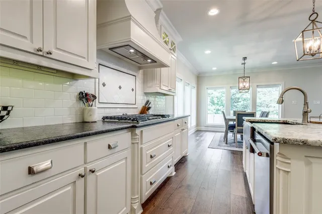 a kitchen with granite countertop a sink stainless steel appliances and cabinets