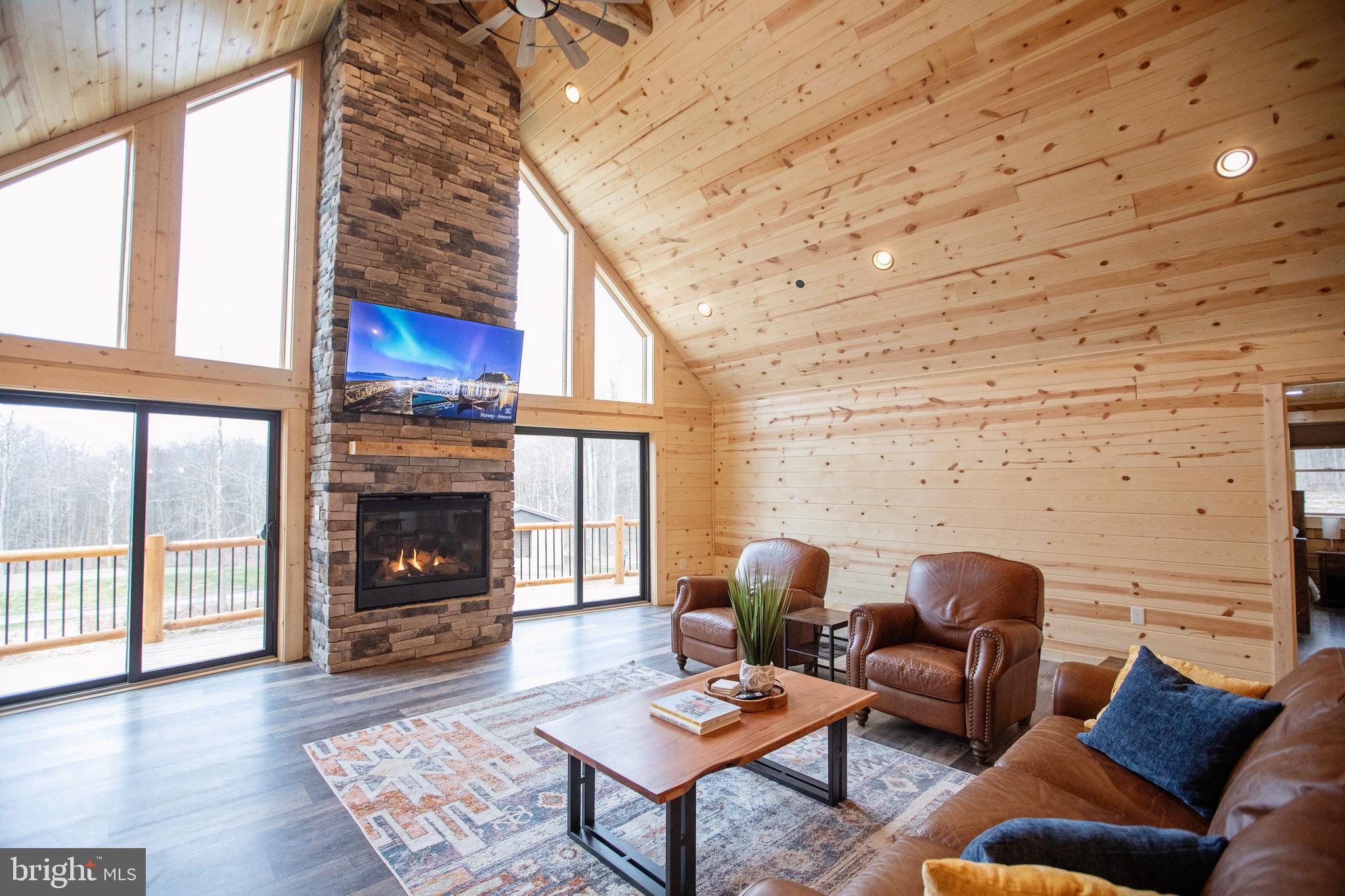 635 Biltmore Rdg Trail McHenry, MD 21541 - Photo 12 of 64 a living room with furniture a fireplace and a floor to ceiling window