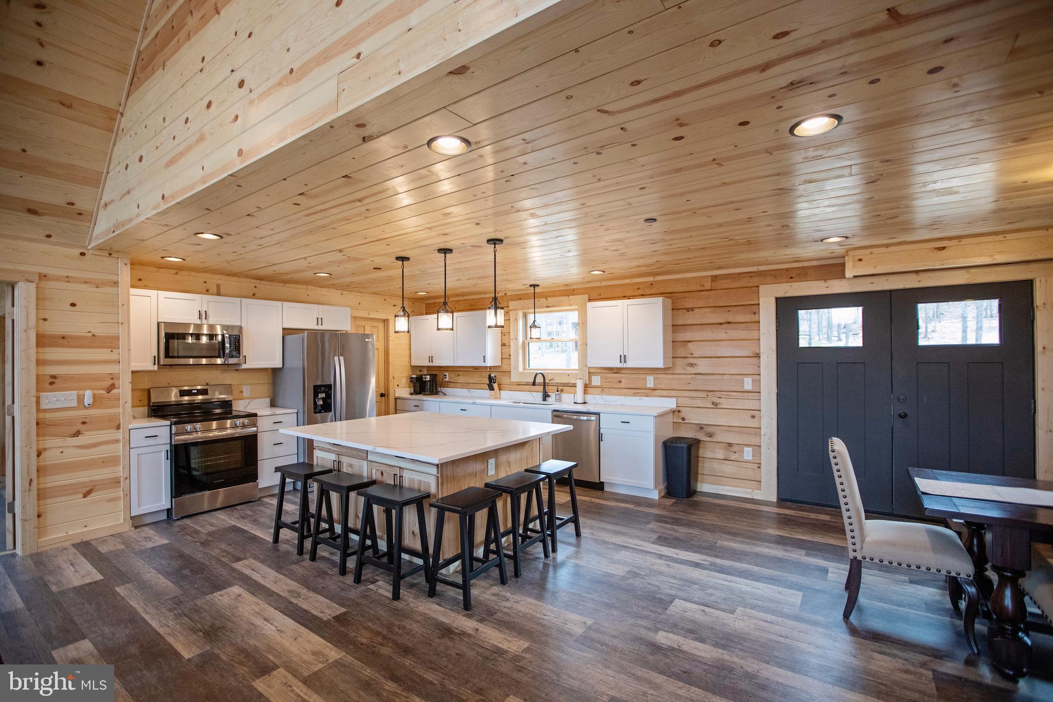 635 Biltmore Rdg Trail McHenry, MD 21541 - Photo 13 of 64 a kitchen with stainless steel appliances granite countertop a stove a refrigerator a kitchen island a dining table and chairs with wooden floor