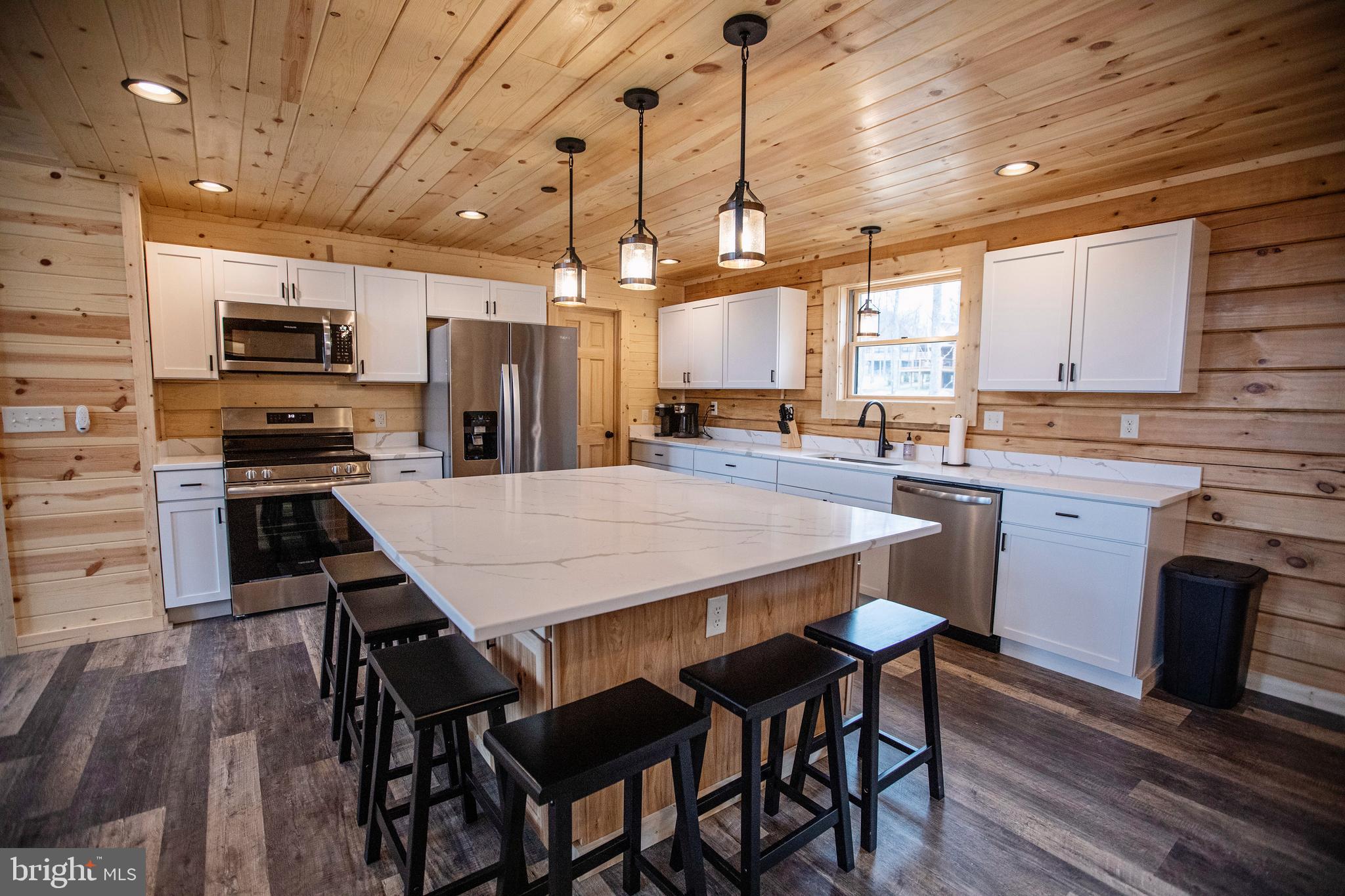 635 Biltmore Rdg Trail McHenry, MD 21541 - Photo 8 of 64 a kitchen with stainless steel appliances a table chairs sink and microwave