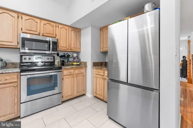 a kitchen with stainless steel appliances a refrigerator sink and microwave