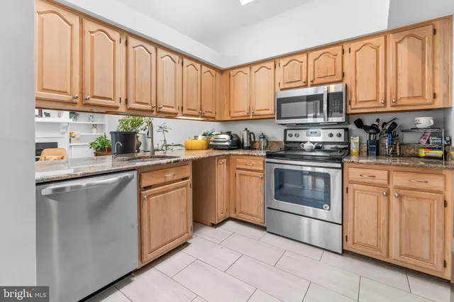 a kitchen with stainless steel appliances granite countertop white cabinets a sink and dishwasher