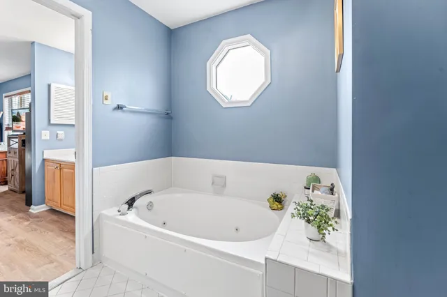 a white bath tub sitting in a bathroom next to a window