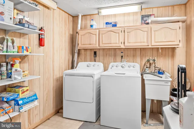 a utility room with fridge dryer and washer