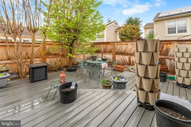 a view of a patio with dining table and chairs with wooden floor and fence