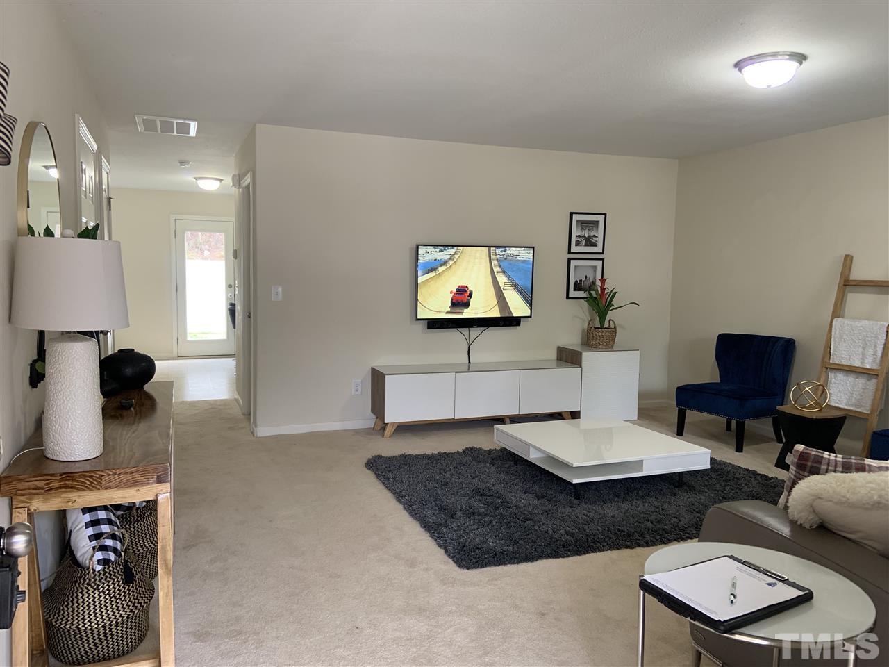2737 Manthorp Terrace Raleigh, NC 27610 - Photo 3 of 21 a living room with furniture a rug and a lamp