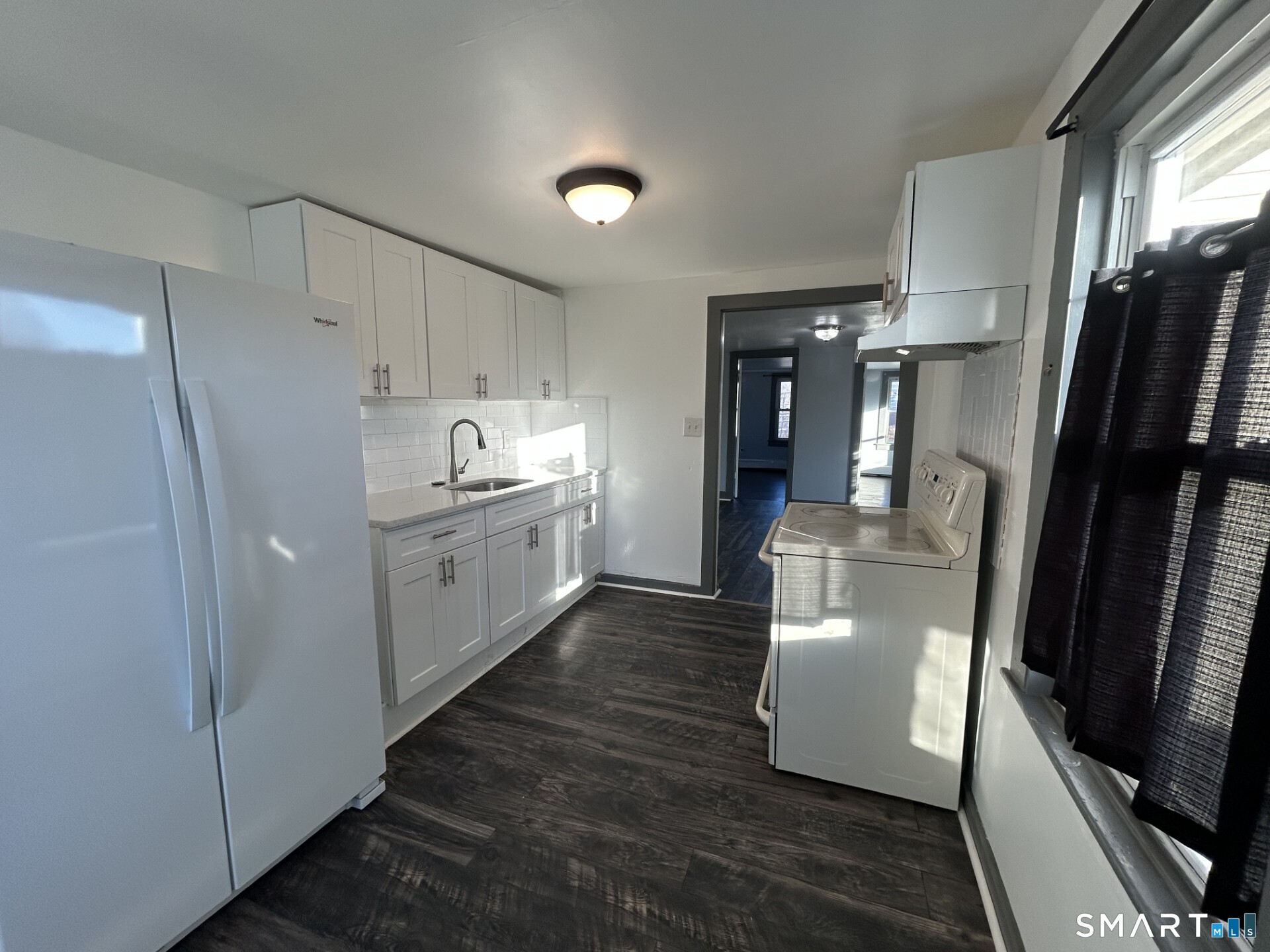 288 Litchfield Street, Unit 2 Torrington, CT 06790 - Photo 2 of 15 a kitchen with refrigerator and white cabinets